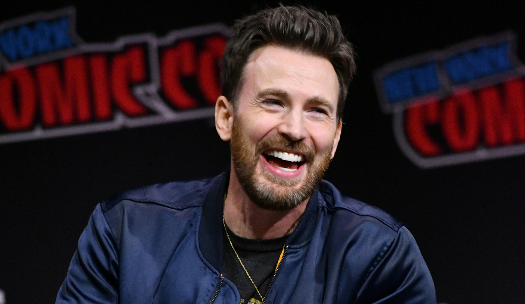 Chris Evans, sneakers, suede sneakers, beige sneakers, mens sneakers, flat sneakers, lace up sneakers, menswear, white soles, rubber soles, jacket, bomber jacket, jeans, black jeans, denim, Comic Con, New York Comic Con