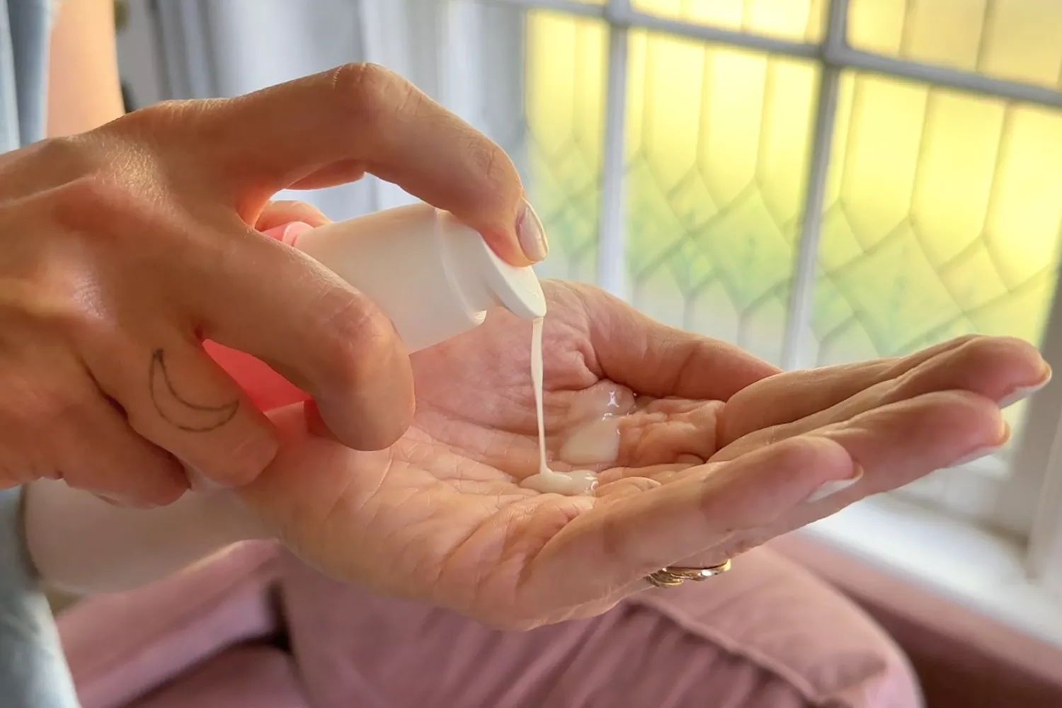 A person pumps Caudalie Vinosource-Hydra SOS Hydrating Hyaluronic Acid Serum into their hand